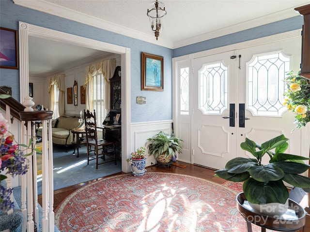 entryway featuring a textured ceiling, hardwood / wood-style flooring, and crown molding