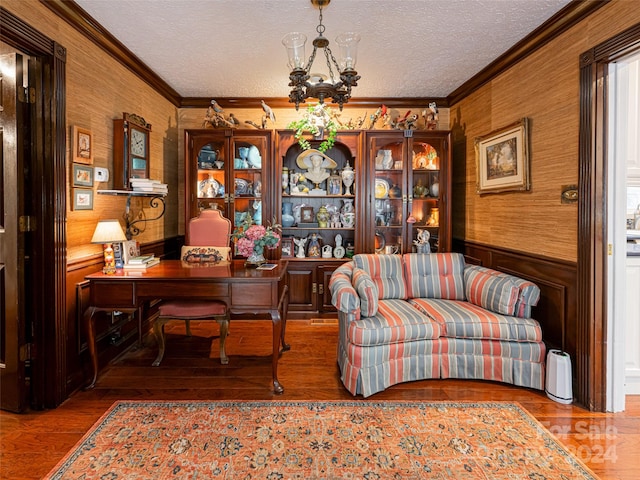 office space with a chandelier, hardwood / wood-style floors, a textured ceiling, and crown molding