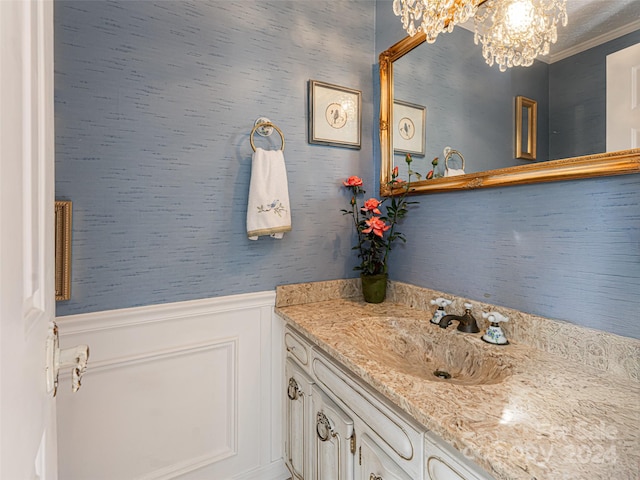 bathroom featuring vanity, ornamental molding, and a chandelier