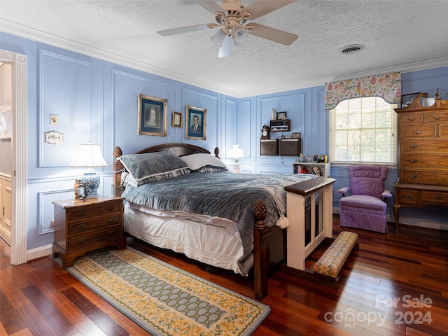 bedroom with ceiling fan, dark hardwood / wood-style floors, and a textured ceiling