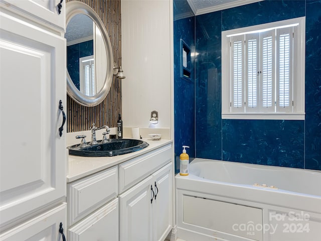 bathroom with a bathing tub, vanity, and ornamental molding