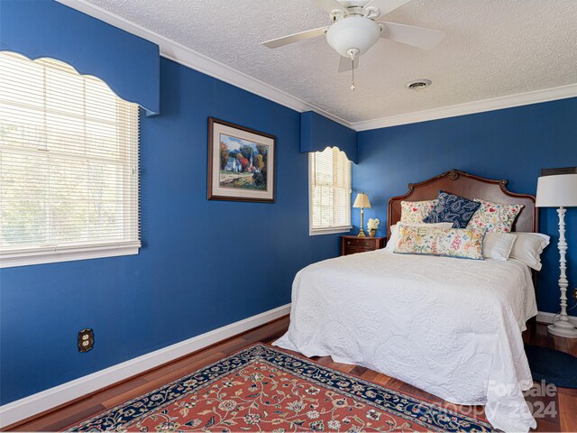 bedroom featuring hardwood / wood-style flooring, ceiling fan, crown molding, and a textured ceiling