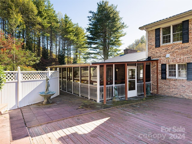 wooden deck with a sunroom