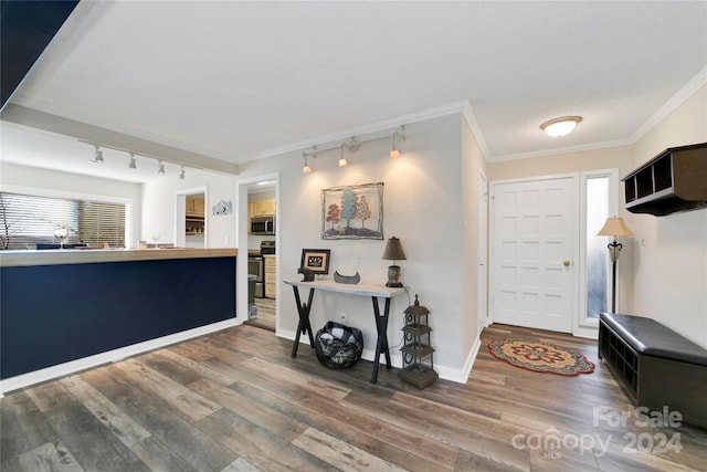 foyer featuring hardwood / wood-style floors, a textured ceiling, and crown molding