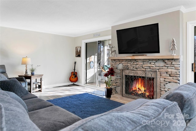 living room with crown molding, a fireplace, and light hardwood / wood-style flooring