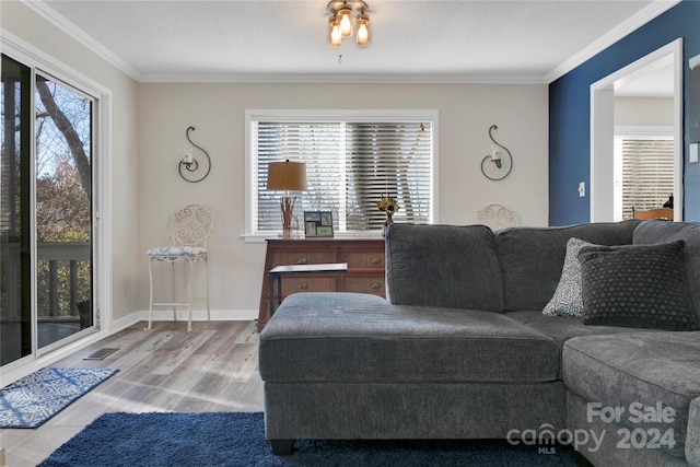 living room featuring crown molding, plenty of natural light, and hardwood / wood-style floors