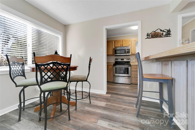 dining area with dark hardwood / wood-style flooring and a textured ceiling