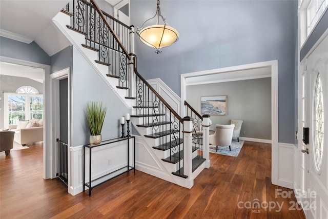 entrance foyer featuring dark wood-type flooring, lofted ceiling, and ornamental molding