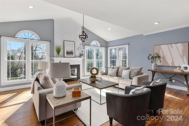 living room with hardwood / wood-style flooring, lofted ceiling, and a notable chandelier