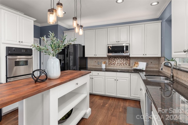 kitchen featuring appliances with stainless steel finishes, sink, white cabinets, dark hardwood / wood-style floors, and butcher block counters