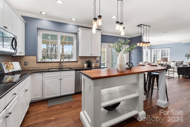 kitchen featuring wood counters, appliances with stainless steel finishes, dark hardwood / wood-style flooring, and white cabinetry