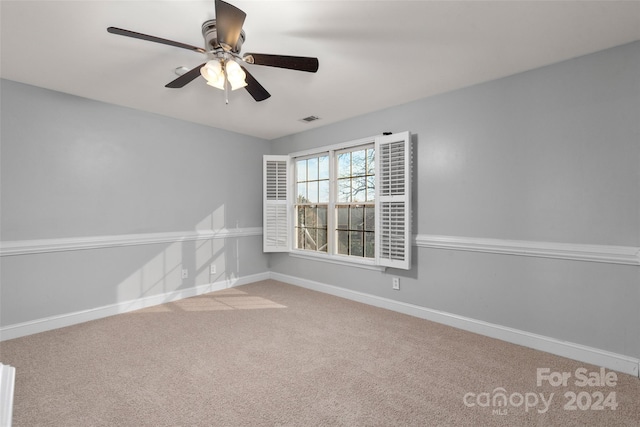 spare room with ceiling fan and carpet