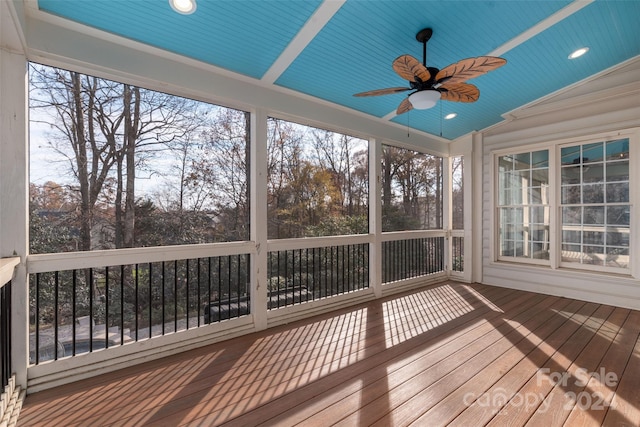 unfurnished sunroom featuring wood ceiling, ceiling fan, lofted ceiling, and a wealth of natural light