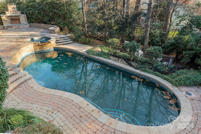 view of pool featuring a patio area and an outdoor stone fireplace