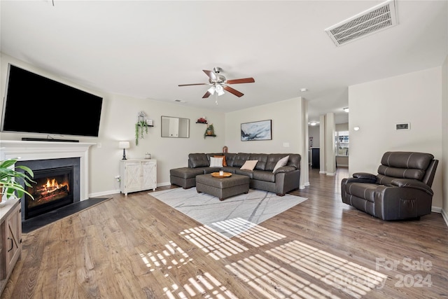 living room featuring ceiling fan and light hardwood / wood-style floors