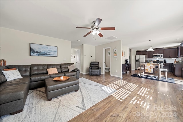 living room featuring hardwood / wood-style flooring and ceiling fan