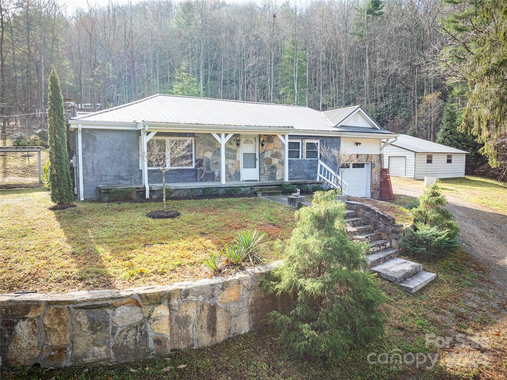 single story home with covered porch and a front yard