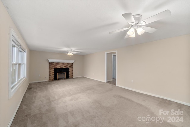 unfurnished living room featuring light carpet, ceiling fan, and a brick fireplace