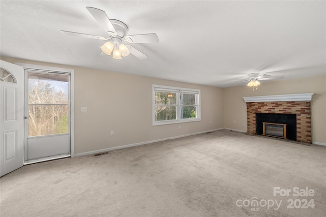 unfurnished living room with light carpet, a brick fireplace, and ceiling fan