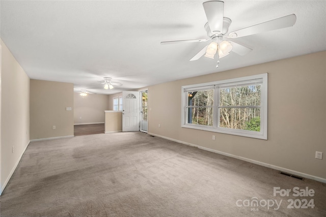 unfurnished living room featuring carpet flooring and ceiling fan