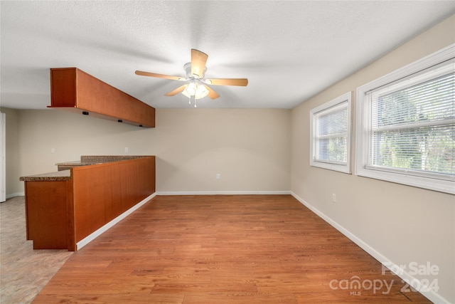 kitchen with a textured ceiling, light hardwood / wood-style floors, and ceiling fan