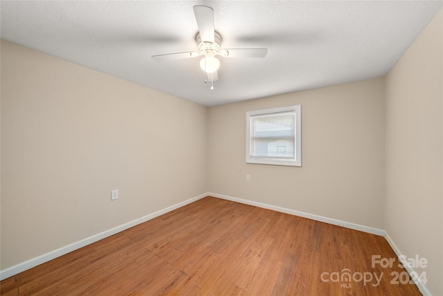 spare room featuring a textured ceiling, light wood-type flooring, and ceiling fan