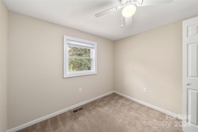 spare room featuring ceiling fan and light colored carpet