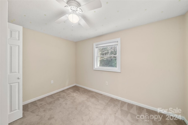 carpeted empty room featuring ceiling fan