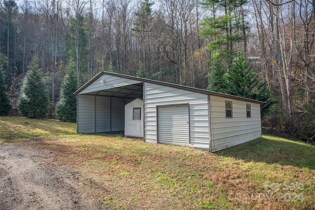 garage with a carport and a yard