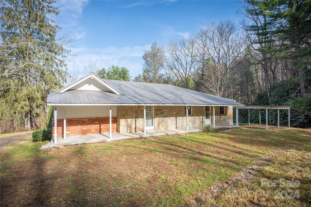 rear view of house with covered porch and a yard