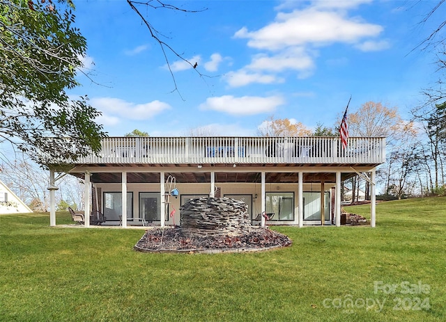 back of house featuring a wooden deck and a yard