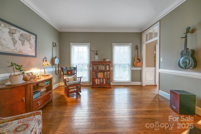 living area with crown molding, baseboards, and wood finished floors