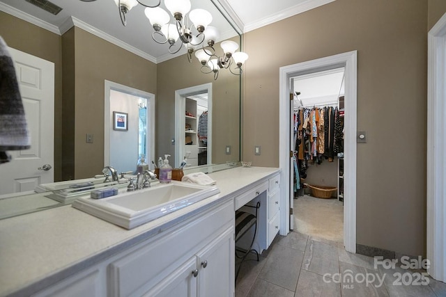 bathroom featuring a walk in closet, visible vents, crown molding, and vanity