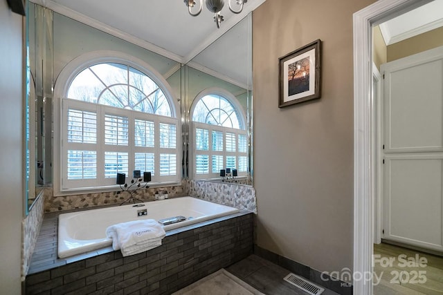 bathroom with visible vents, ornamental molding, and a bath