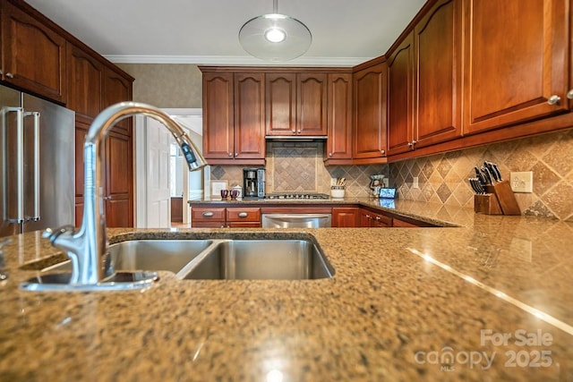 kitchen featuring appliances with stainless steel finishes, ornamental molding, a sink, light stone countertops, and backsplash