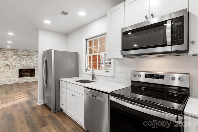 kitchen featuring dark hardwood / wood-style flooring, white cabinetry, sink, and appliances with stainless steel finishes