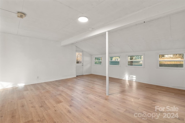 unfurnished living room with lofted ceiling with beams and light hardwood / wood-style floors