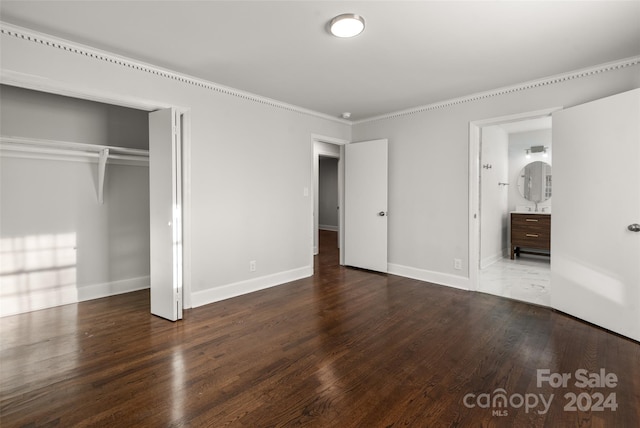 unfurnished bedroom featuring hardwood / wood-style floors, ensuite bathroom, and a closet