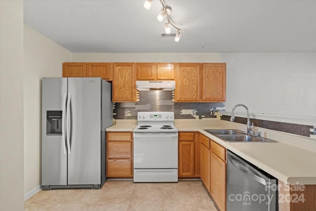 kitchen featuring decorative backsplash, sink, light tile patterned floors, and appliances with stainless steel finishes