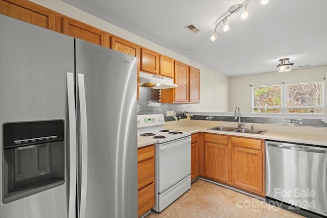 kitchen with decorative backsplash, sink, light tile patterned floors, and stainless steel appliances