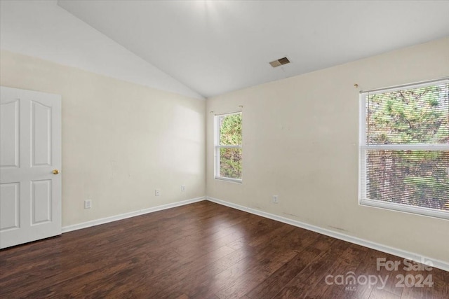 empty room with dark hardwood / wood-style flooring and lofted ceiling