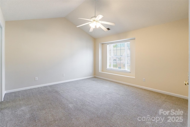 spare room featuring lofted ceiling, carpet, a ceiling fan, and baseboards