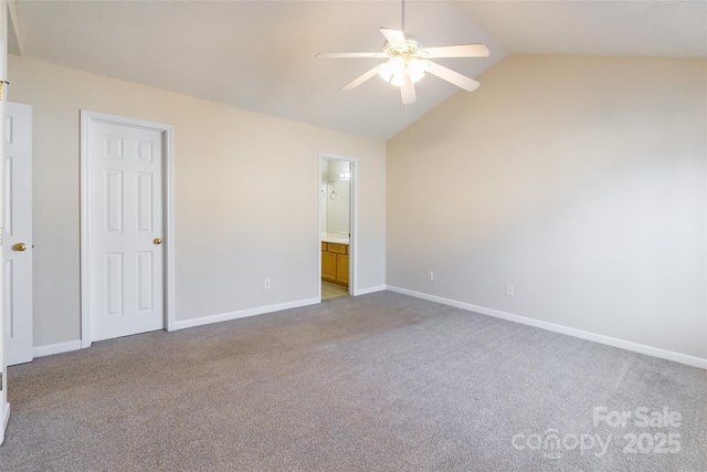 unfurnished bedroom with carpet floors, baseboards, vaulted ceiling, and connected bathroom