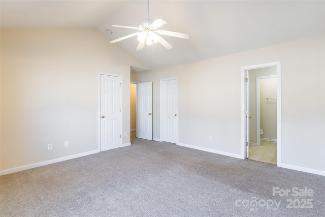 unfurnished bedroom featuring ensuite bathroom, high vaulted ceiling, ceiling fan, carpet flooring, and baseboards