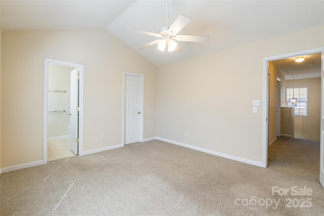 unfurnished bedroom featuring ensuite bath, carpet, baseboards, and vaulted ceiling