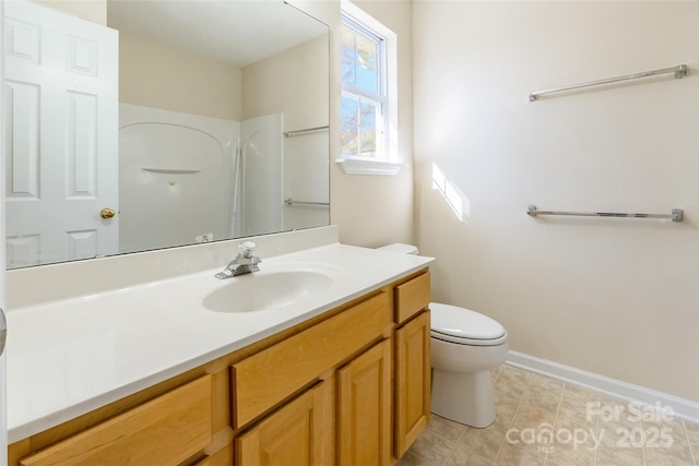 bathroom featuring toilet, baseboards, and vanity