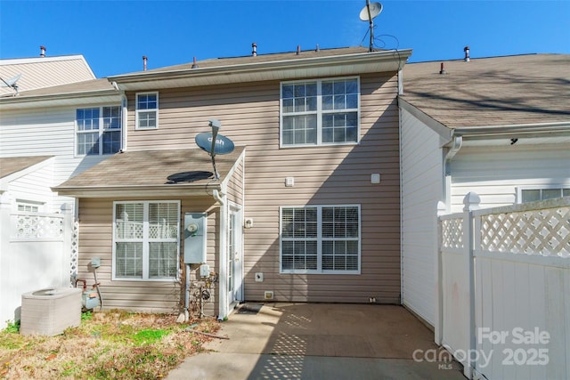 back of property with cooling unit, a patio area, and fence