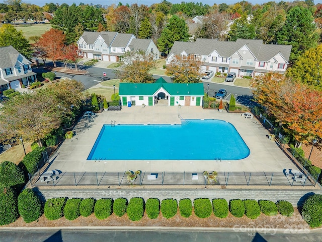 view of swimming pool with a residential view, fence, and a patio