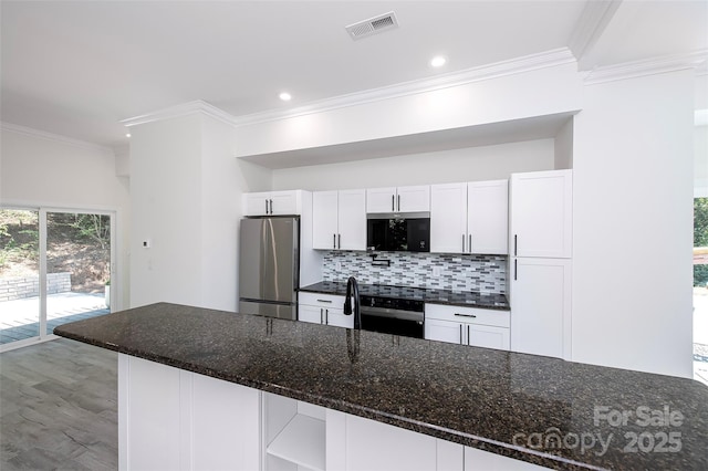 6534 Providence Rd, Charlotte, NC 28226 - kitchen featuring freestanding refrigerator, wall oven, ornamental molding, white cabinets, and tasteful backsplash