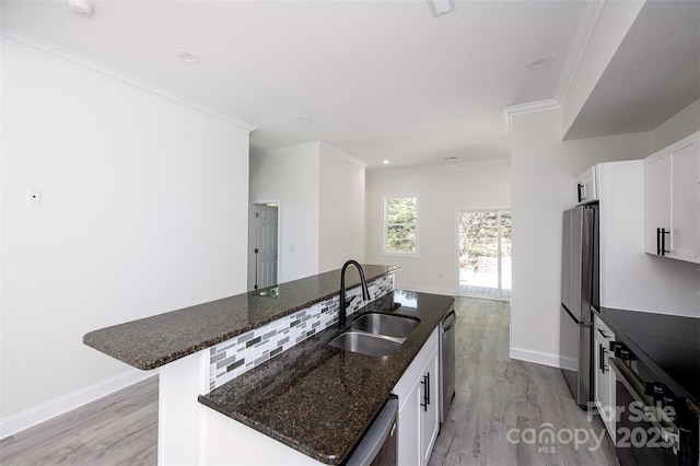 6534 Providence Rd, Charlotte, NC 28226 - kitchen featuring light wood-style floors, appliances with stainless steel finishes, an island with sink, and a sink